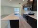 Kitchen with a large island, stainless steel appliances, dark cabinets, and an open layout at 1995 Iorio St, St Cloud, FL 34771