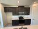Stylish kitchen with dark cabinetry, stainless steel appliances, and a quartz countertop island at 1995 Iorio St, St Cloud, FL 34771