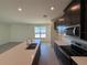 Modern kitchen featuring a spacious island, dark cabinets, and stainless steel appliances at 1995 Iorio St, St Cloud, FL 34771