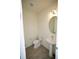 This powder room features a pedestal sink, oval mirror, and tile floors at 1995 Iorio St, St Cloud, FL 34771