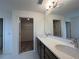 Bathroom featuring double vanity, a large mirror, and a view of a closet at 1996 Heart Lake Dr, Groveland, FL 34736