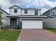 Charming two-story home featuring a red brick driveway and a two-car garage at 1996 Heart Lake Dr, Groveland, FL 34736