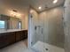 Large primary bathroom with double vanity, quartz countertop, and glass-enclosed shower at 1996 Heart Lake Dr, Groveland, FL 34736
