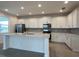 Bright kitchen featuring white cabinets, stainless steel appliances, and a center island at 2000 Heart Lake Dr, Groveland, FL 34736
