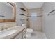 Bathroom featuring single sink vanity, framed mirror, open shelving, and tiled walk-in shower at 2102 Nedra Ave, Deltona, FL 32725