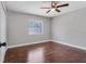 Cozy bedroom with hardwood floors, ceiling fan, and a window providing natural light at 2102 Nedra Ave, Deltona, FL 32725