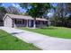 Charming single-story home boasts a well-manicured lawn, mature tree, and a long driveway leading to the front entrance at 2102 Nedra Ave, Deltona, FL 32725