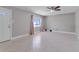 Bright living room featuring tile flooring, a ceiling fan, and a window with pink curtains at 2102 Nedra Ave, Deltona, FL 32725