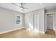 Bedroom with light wood floors, ceiling fan, and a view into the en suite bathroom at 211 E Muriel St, Orlando, FL 32806