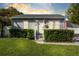 Charming single-story home with gray siding, manicured hedges, and a well-maintained lawn at 211 E Muriel St, Orlando, FL 32806