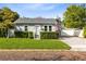 Charming home featuring gray siding, manicured hedges, and a brick-paved driveway at 211 E Muriel St, Orlando, FL 32806