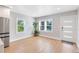 Bright living room featuring refinished hardwood floors, a modern front door, and natural light at 211 E Muriel St, Orlando, FL 32806