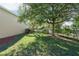 Beautiful backyard featuring lush green grass, a mature tree, and a classic wrought iron fence at 2523 Water Valley Dr, St Cloud, FL 34771