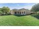 Lovely backyard with a well-manicured lawn, mature trees, and a tan home exterior with sliding glass doors at 2523 Water Valley Dr, St Cloud, FL 34771