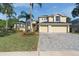 Charming home featuring a three-car garage, well-manicured lawn, and lush tropical landscaping at 2523 Water Valley Dr, St Cloud, FL 34771