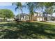 Landscaped front yard featuring a spacious lawn, mature trees, and a charming two-story home at 2523 Water Valley Dr, St Cloud, FL 34771