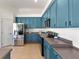 Stylish kitchen showcasing teal cabinets, stainless steel appliances, and a functional layout at 2523 Water Valley Dr, St Cloud, FL 34771