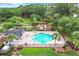 Aerial view of a community pool surrounded by lounge chairs, playground, and lush greenery at 2523 Water Valley Dr, St Cloud, FL 34771
