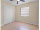 Bright bedroom with a ceiling fan, window with blinds, tile floors, and a closet with sliding doors at 2605 S Elm Ave, Sanford, FL 32773