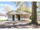 Charming single-Gathering home featuring dual entry doors, neutral paint, and a mature shade tree at 2605 S Elm Ave, Sanford, FL 32773