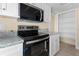 Updated kitchen features stainless steel appliances, granite countertops, and white cabinets at 2605 S Elm Ave, Sanford, FL 32773