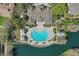 Aerial view of community pool and clubhouse located next to the lake and surrounding greenery at 2679 Metro Sevilla Dr # 101, Orlando, FL 32835
