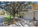 Charming condo exterior with attached garage and well-maintained landscaping, nestled beneath a beautiful mature tree at 2679 Metro Sevilla Dr # 101, Orlando, FL 32835