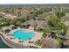 Aerial view of a community pool surrounded by lounge chairs, palm trees, and a lake at 2679 Metro Sevilla Dr # 101, Orlando, FL 32835