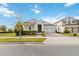 Charming single-story home with a two-car garage, manicured lawn, and beautiful landscaping under a bright, cloudy sky at 2951 Irish Peach Dr, Winter Garden, FL 34787
