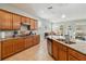 Well-lit kitchen showcasing wooden cabinets, granite countertops, stainless steel appliances, and a center island with a sink at 2951 Irish Peach Dr, Winter Garden, FL 34787