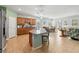 Bright kitchen with island, granite countertops, wooden cabinets, stainless appliances, flowing into the living and dining areas at 2951 Irish Peach Dr, Winter Garden, FL 34787