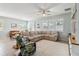 Bright living room featuring a sectional sofa, ceiling fan, and large windows with plantation shutters at 2951 Irish Peach Dr, Winter Garden, FL 34787