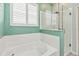 Main bathroom featuring a soaking tub with shower head and glass enclosure at 2951 Irish Peach Dr, Winter Garden, FL 34787