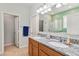 Bright bathroom featuring a double sink vanity with granite countertops and a walk-in shower at 2951 Irish Peach Dr, Winter Garden, FL 34787