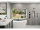This bathroom features a standalone tub beneath a window, as well as a glass shower enclosure at 315 E 6Th Ave, Windermere, FL 34786