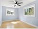 Bright bedroom features hardwood floors, light blue walls, and two windows at 315 E 6Th Ave, Windermere, FL 34786