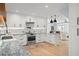 Well-lit kitchen with stainless steel appliances, ample counter space, white cabinetry, and view into the cozy living room at 315 E 6Th Ave, Windermere, FL 34786