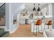 Open-concept kitchen with bar seating, stainless appliances, sleek countertops, and easy access to the staircase at 315 E 6Th Ave, Windermere, FL 34786