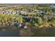 Aerial view of waterfront property with private dock, boat lift, and neighborhood beyond at 3279 Landing Vw, Tavares, FL 32778