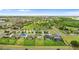 Beautiful aerial view of a residential neighborhood with green spaces, tennis courts, and well-maintained lawns at 3279 Landing Vw, Tavares, FL 32778