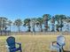 Serene backyard featuring a well-manicured lawn and stunning views of the tranquil lake at 3279 Landing Vw, Tavares, FL 32778