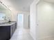 Well-lit bathroom featuring a granite countertop, ceramic tile flooring, and a glass door shower at 3279 Landing Vw, Tavares, FL 32778