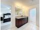 Open bathroom view showcasing a granite countertop, ceramic tile flooring, and a door to main bedroom at 3279 Landing Vw, Tavares, FL 32778