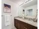 Bathroom featuring a granite countertop, double sinks, and a decorative flower arrangement at 3279 Landing Vw, Tavares, FL 32778