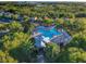 Aerial view of community pool with palm trees, lounge chairs and surrounding greenery at 3279 Landing Vw, Tavares, FL 32778