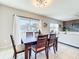Bright dining area with large windows, stylish lighting, and an open layout connecting to the living space at 3279 Landing Vw, Tavares, FL 32778