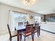 The dining room has a large table and chairs, a large window, and is open to the living room at 3279 Landing Vw, Tavares, FL 32778