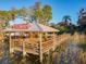 Waterfront dock with covered area and walkway in lush setting at 3279 Landing Vw, Tavares, FL 32778