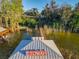 Tranquil view from the Etowah dock featuring a scenic walkway and waterfront home in the background at 3279 Landing Vw, Tavares, FL 32778