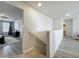 Upstairs hallway featuring wood-look floors and bedroom with large window and blinds at 3279 Landing Vw, Tavares, FL 32778
